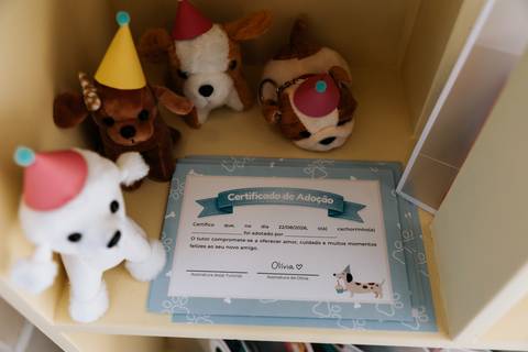Lembrancinhas em formato de cachorrinhos e certificado de adoção fazem parte da decoração da festa de 1 ano da Olívia.'