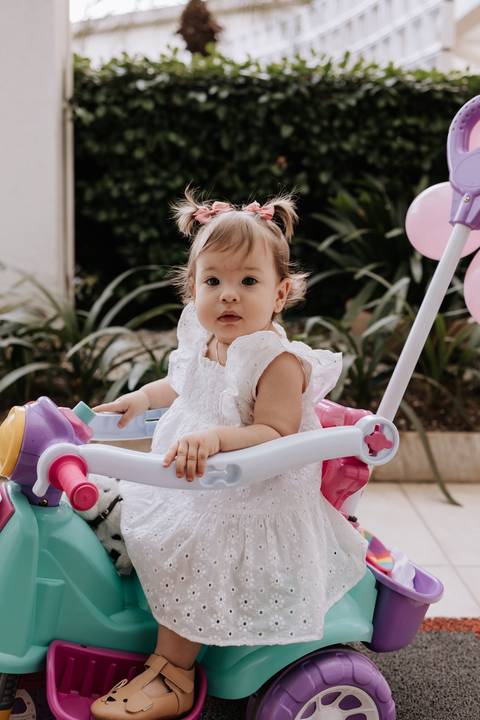 Olívia brinca em um brinquedo infantil durante sua festa de 1 ano.'