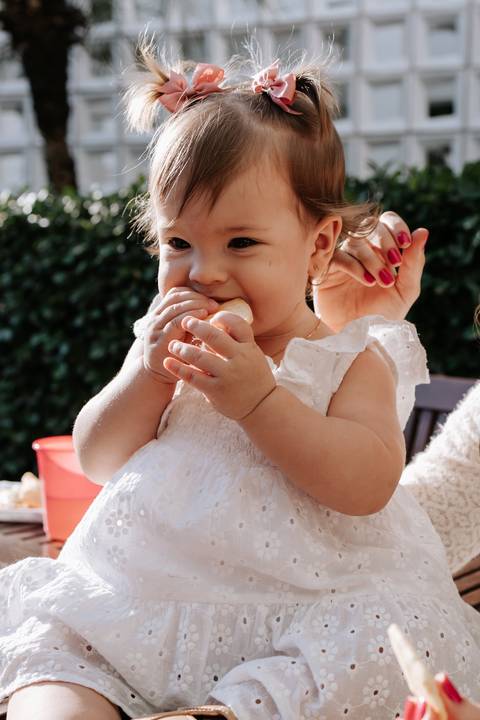 Olívia comendo durante sua festa de 1 ano.'