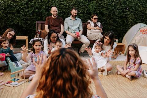 Crianças e familiares reunidos em uma atividade de recreação durante a festa.'