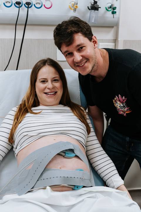Jessica e Fabricio posam juntos na maternidade, aguardando a chegada da filha Maria Clara.'