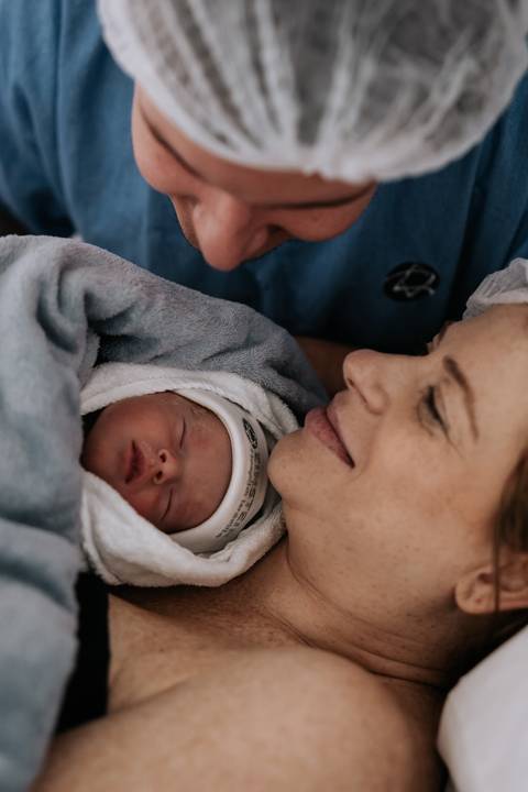 Jessica contempla Maria Clara deitada ao seu lado, enquanto Fabricio se aproxima para compartilhar esse primeiro encontro em família.'