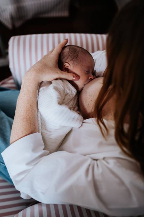 Maria Clara mama no colo da mãe enquanto Jessica a acolhe com delicadeza, em um registro íntimo dos primeiros dias de amamentação.'