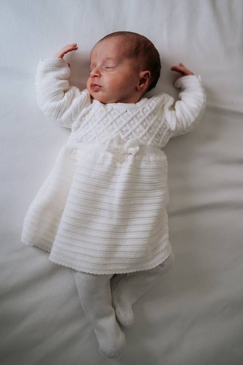 Maria Clara usando vestidinho de tricô branco.'