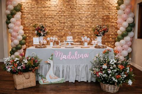 Mesa principal da festa de 1 ano da Madalena, decorada com flores, balões e detalhes encantadores no tema gansinho.'