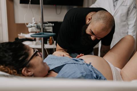 Bruno se inclina para beijar a barriga de Yasmin, em um gesto de carinho e conexão com Julieta.'