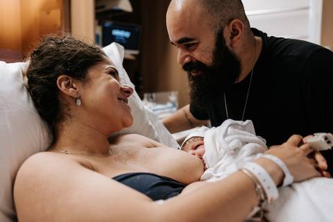 Yasmin sorri emocionada enquanto segura Julieta nos primeiros momentos após o nascimento.'