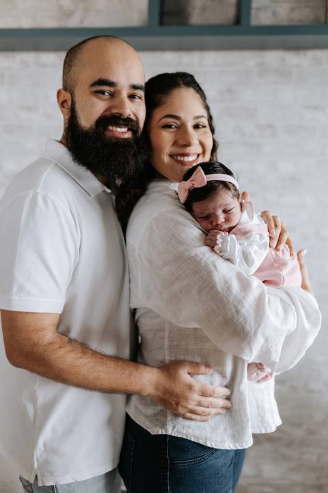 Papai abraçando a mamãe e a pequena Julieta.'