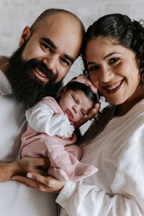 Família reunida em um abraço cheio de amor com a recém-nascida Julieta.'