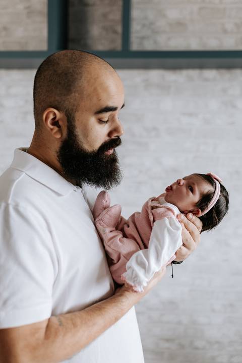 Papai segurando Julieta nos braços e admirando os primeiros dias da filha.'