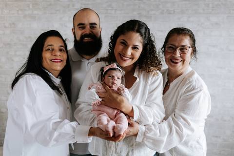 Julieta no colo da família, cercada de amor e aconchego.'