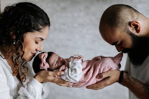 Yasmin e Bruno contemplando Julieta juntos em um momento delicado em família.'