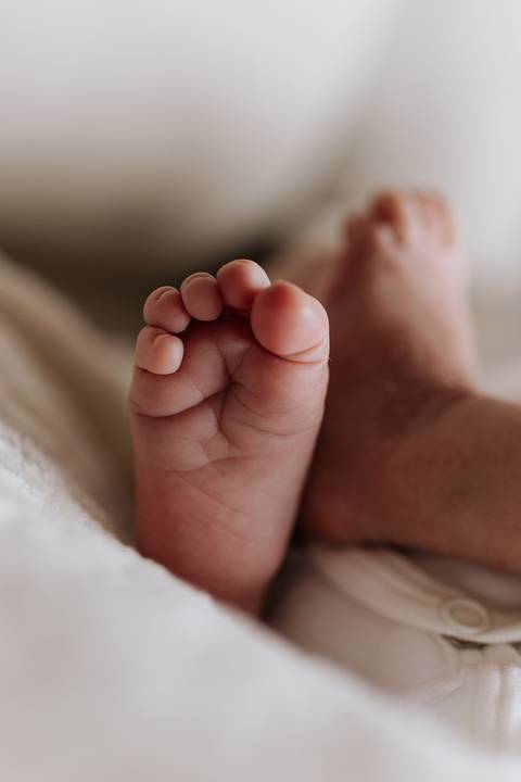 Close dos pezinhos de Julieta, registrando os pequenos detalhes dos seus primeiros dias de vida.'