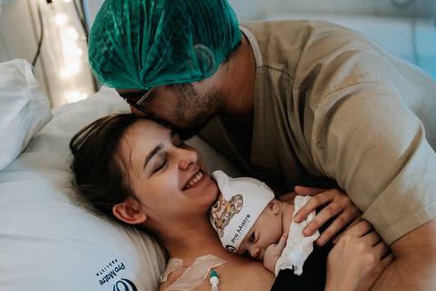 Samuel ao lado de Ana Carolina e Ana Clara, emocionado ao conhecer a filha nos primeiros instantes após o nascimento.'