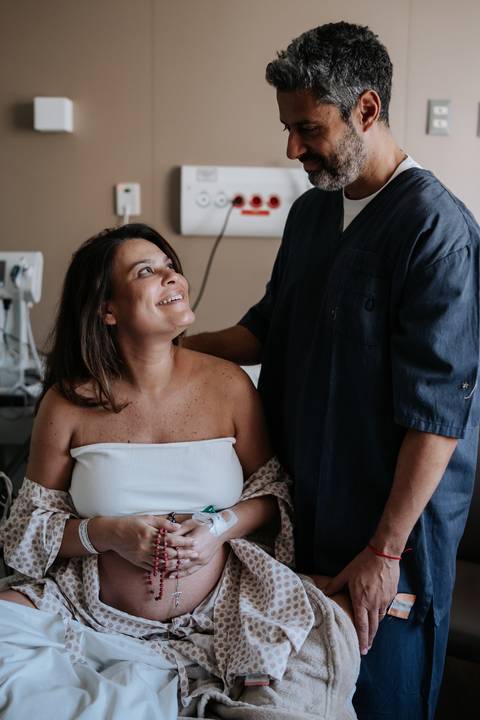 Marina sorrindo enquanto conversa com José Carlos no quarto da Maternidade São Luiz Star.'