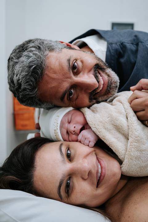 Retrato de família com José Carlos e Marina deitados lado a lado com José Joaquim aconchegado.'