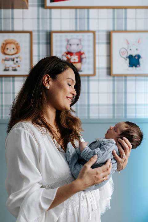 Marina sorridente olhando com ternura para o filho José Joaquim em seus braços.'