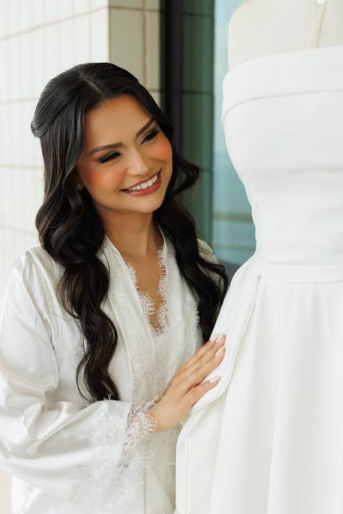 Noiva contemplando o vestido antes da cerimônia de casamento.'
