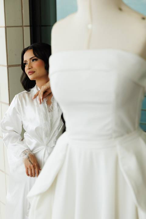 Noiva contemplando o vestido antes da cerimônia de casamento.'
