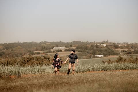 Noivos correndo no campo'