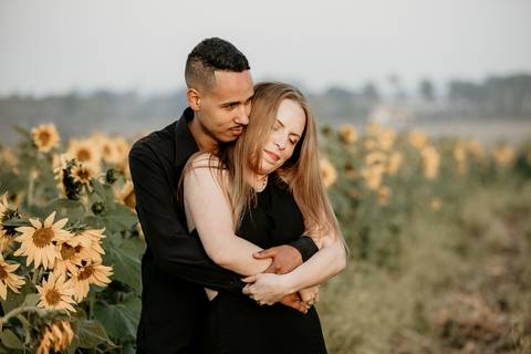 Noivos abraçados no campo de girassol'