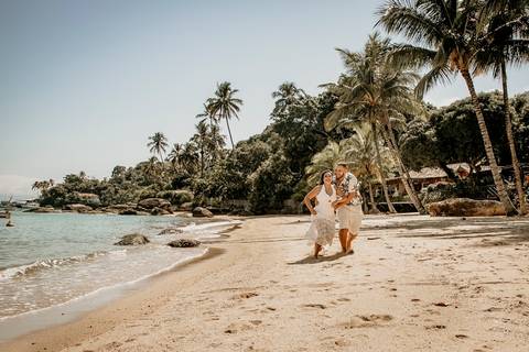 casal correndo na praia'