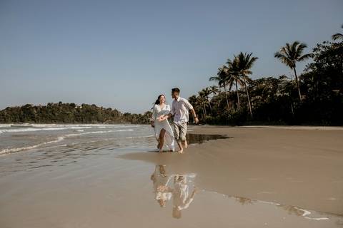 foto com Noivos correndo na praia'