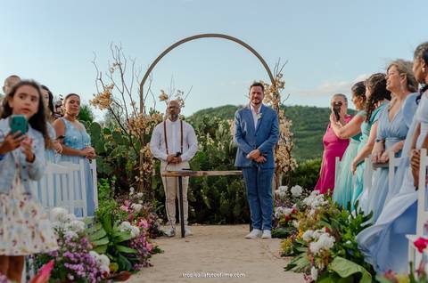 Casamento no por do sol de Alexandre Kapiche e Mayara Rodrigues. Decoração colorida e tropical na Enseada Azul em Búzios - RJ.'