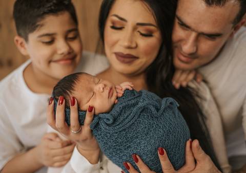 família olhando bebê'