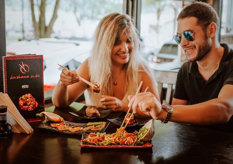 casal comendo sushi'