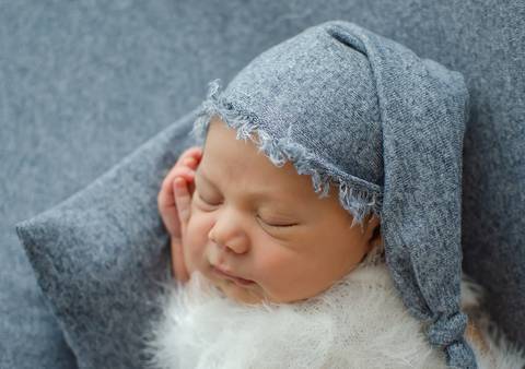 bebê com mãozinha no rosto em ensaio newborn'