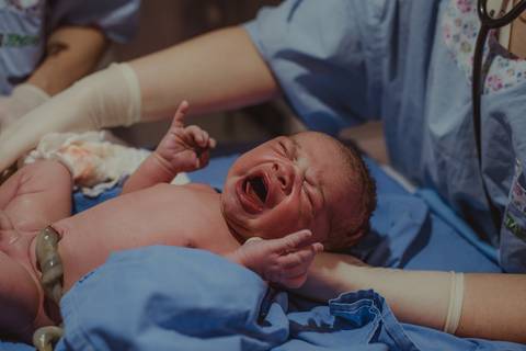 bebê chorando durante procedimentos neonatais'