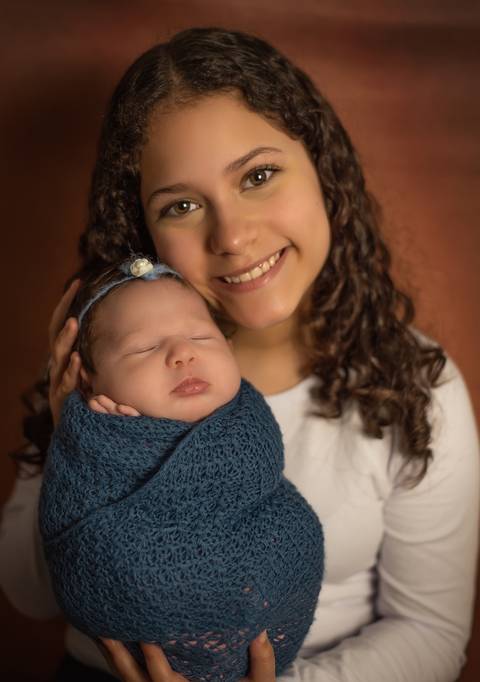 irmã mais velha com bebê no ensaio newborn'