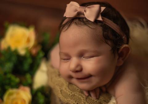 bebê sorrindo durante ensaio newborn'