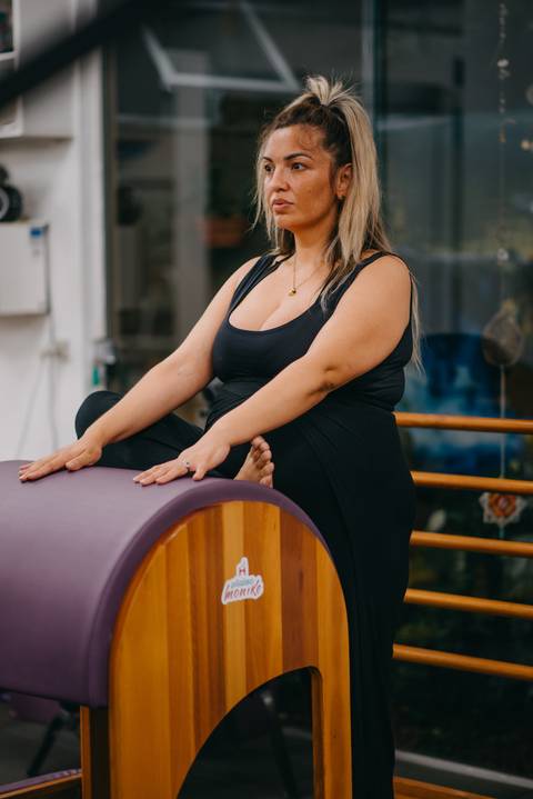gestante alongando ciático em aparelho de pilates'
