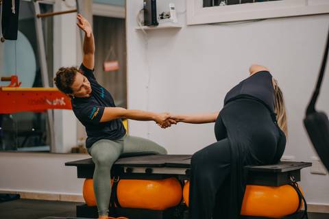 gestante e instrutora alongando'