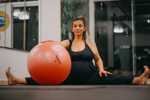 alongamento com bola de pilates, gestante de 40 semanas'