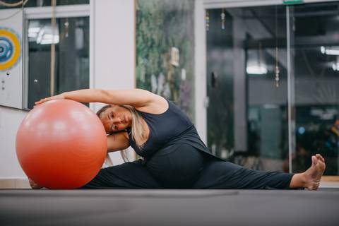 alongamento com bola de pilates rotacionando'