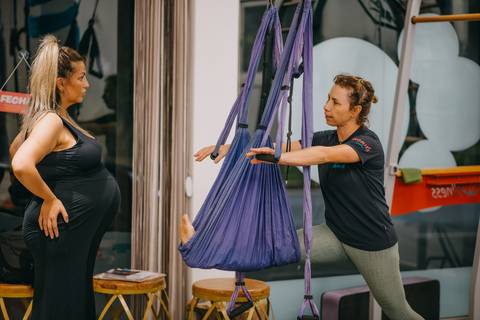 instrutora mostrando para gestante  como fazer o exercício'