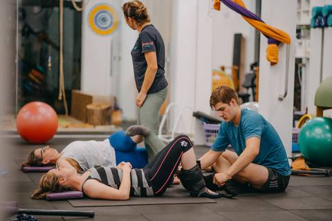 instrutores com alunos em academia de pilates'