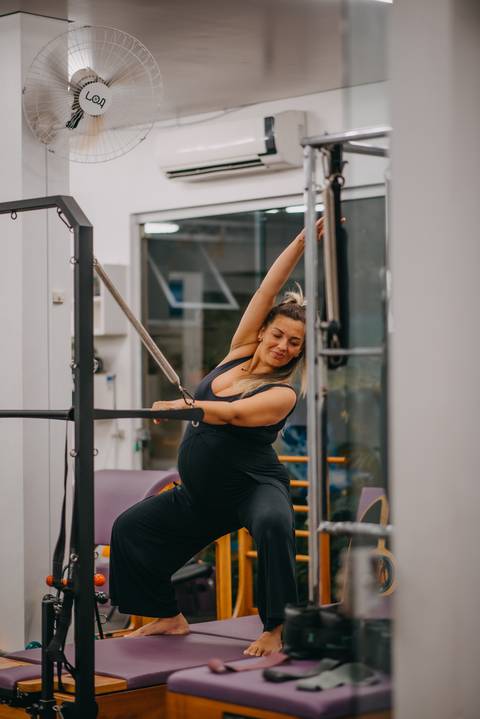 gestante fazendo exercício em aparelho de pilates'