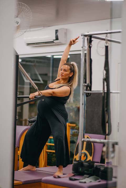 alongamento de gestante em aparelho de pilates'