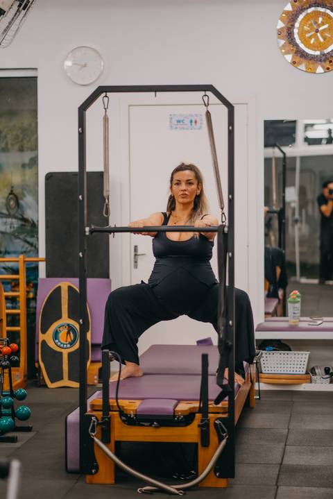 gestante usando aparelho de barras de pilates'