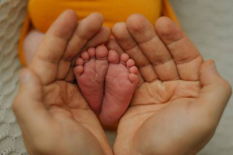 detalhe dos pezinhos do bebê em ensaio newborn de recém-nascido'