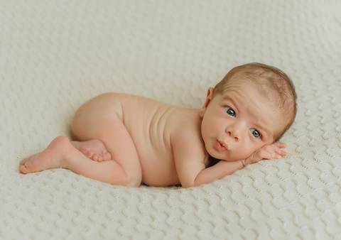 foto newborn de bebê com olhos em pose tradicional em ensaio newborn de recém-nascido'