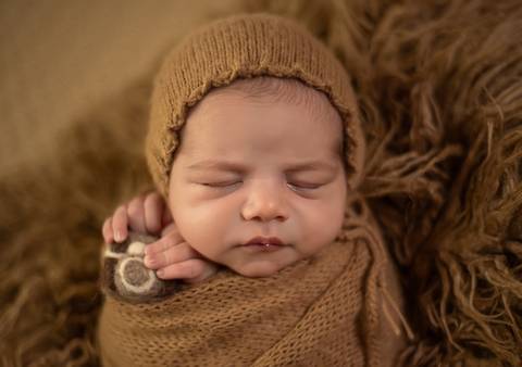 bebê com camera de feltragem em ensaio newborn de recém-nascido'