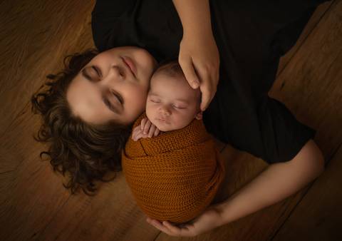 fotografia feita no chão com irmãos em ensaio newborn de recém-nascido'