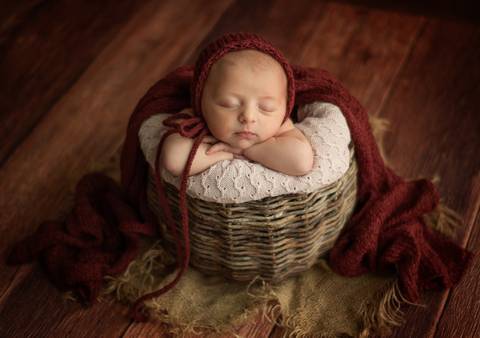 bebê dentro de cesto deitado sobre os braços - ensaio newborn por Aline Fontes fotógrafa de Bento Gonçalves'