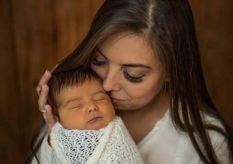 mamãe beijando bebê em ensaio newborn'