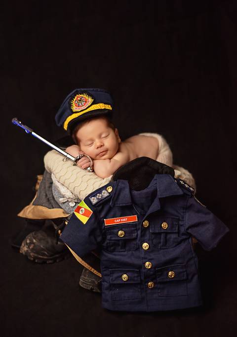 bebê com réplica da réplica mini da  Espadim, que recebe o nome de seu patrono, ou seja, Espadim D. Pedro II'